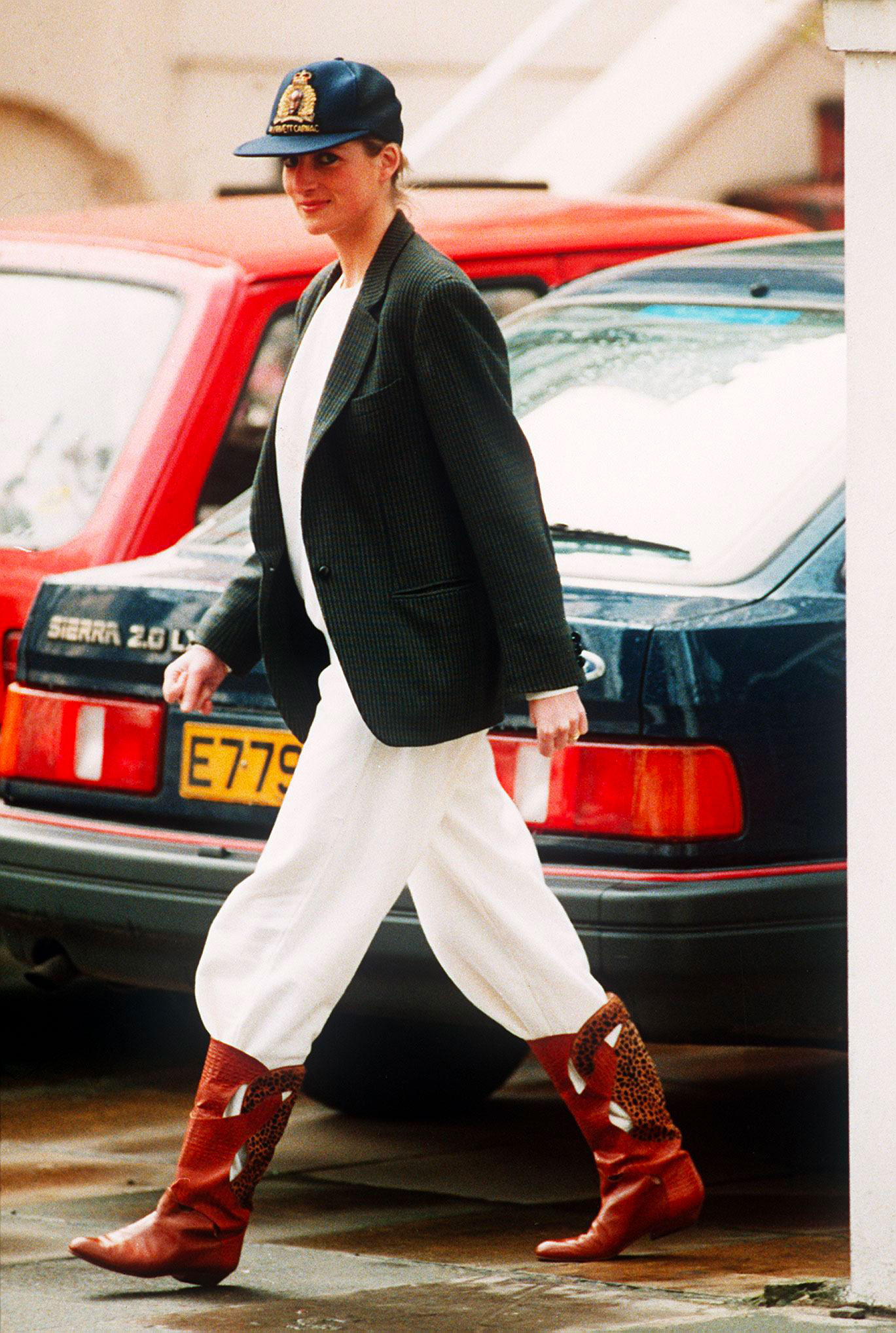 Princess Diana in 1989, sporting a stunning ensemble of wide-leg white pants, a blazer layered over a shirt, and ankle boots.  © Photo by Daily Mirror/Mirrorpix/Getty Images